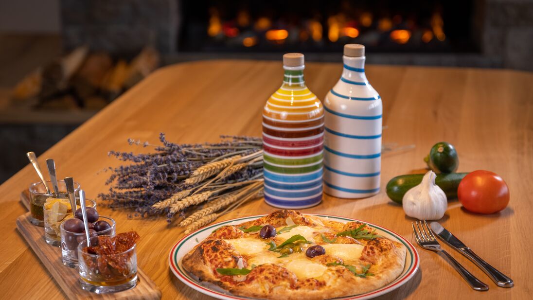 Delicious pizza with ingredients on a table in Das Panorama restaurant. | © Nikolaus Faistauer Photography