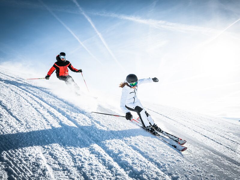 Zwei Skifahrer fahren auf einer schneebedeckten Piste. | © Intersport Bründl