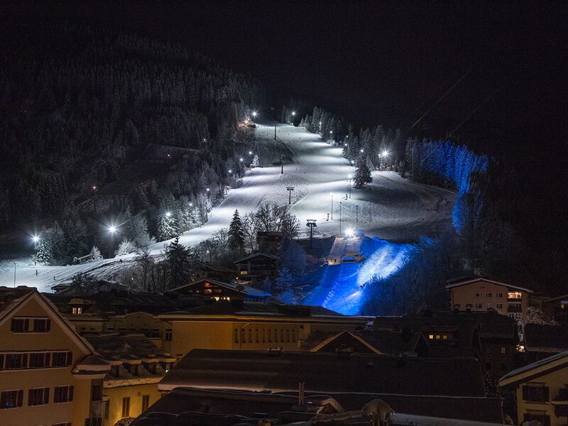 Beleuchtete Skipiste mit Sessellift in der Nacht. | © Schmittenhöhebahn AG/Nikolaus Faistauer Photography