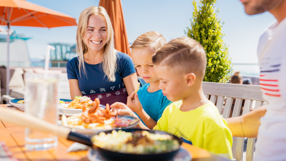 A family enjoys their meal outside at the Franzl mountain restaurant. | © mr-offenblende.at