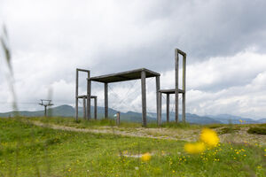 Eine kunstvolle Struktur auf der Wiese, umgeben von Bergen. | © Schmittenhöhebahn AG/mr-offenblende.at