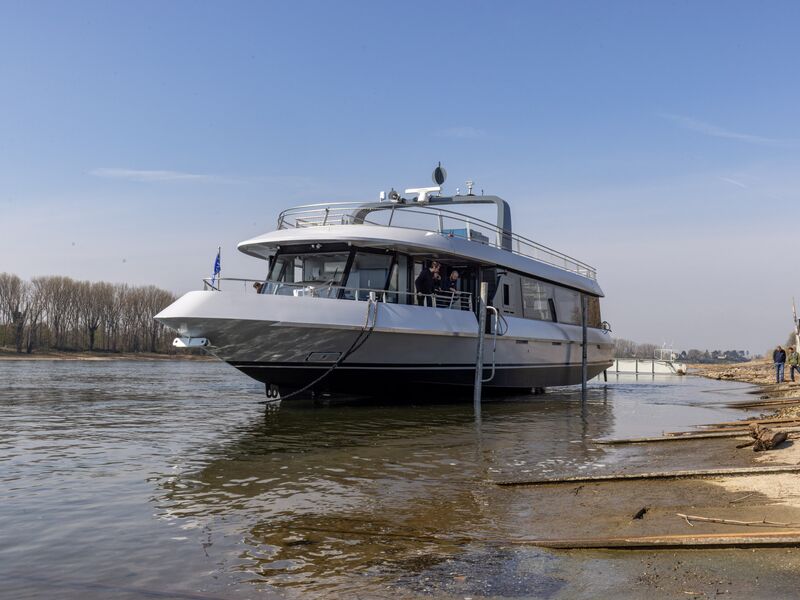 Ein modernes Schiff liegt am Ufer eines Flusses mit blauem Himmel. | © Schmittenhöhebahn AG
