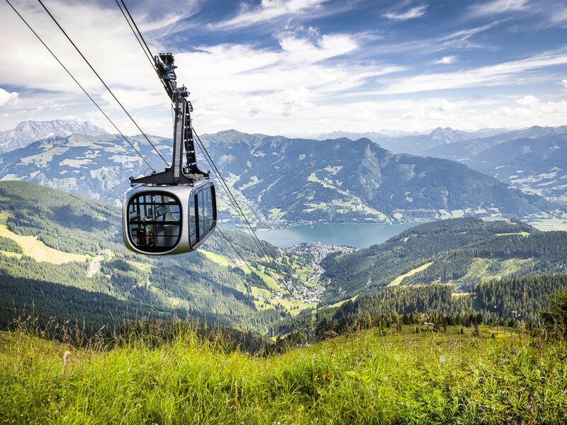 Seilbahn über grüne Täler mit Blick auf Zell am See. | © Max Steinbauer