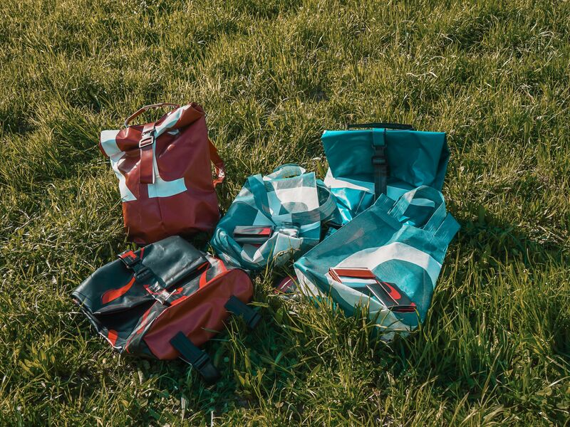 Fünf bunte Taschen liegen auf einer Wiese. | © Schmittenhöhebahn AG