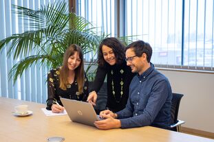 Drei Personen diskutieren und schauen auf einen Laptop. | © Nikolaus Faistauer Photography