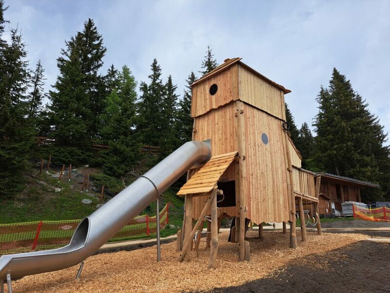 Großer hölzerner Spielturm mit Rutsche in Waldumgebung. | © Fun Connection